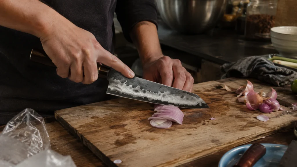 kiritsuke artisanal coupe d'une échalote sur une planche en bois